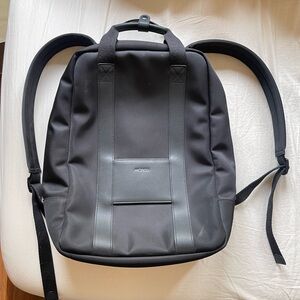 MONOS Modern Black Backpack Unisex, front clip on pouches and water bottle.